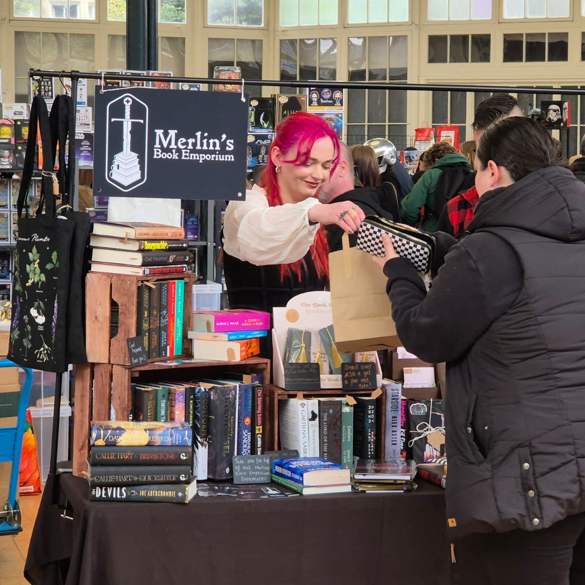 Person interacting with a book vendor at a book fair